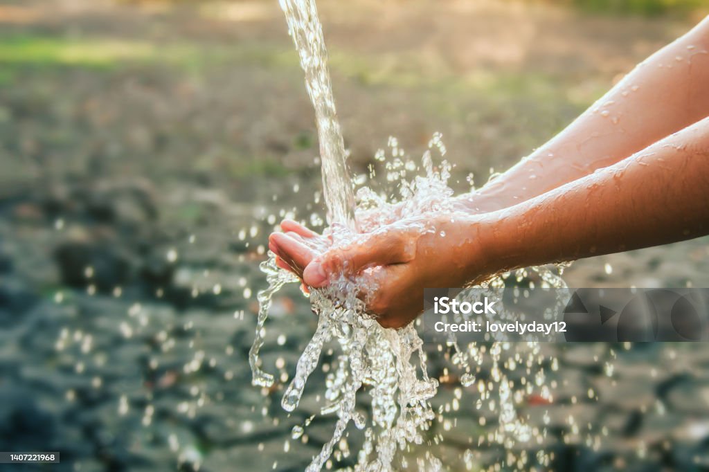 Water pouring on hand in morning ligth background